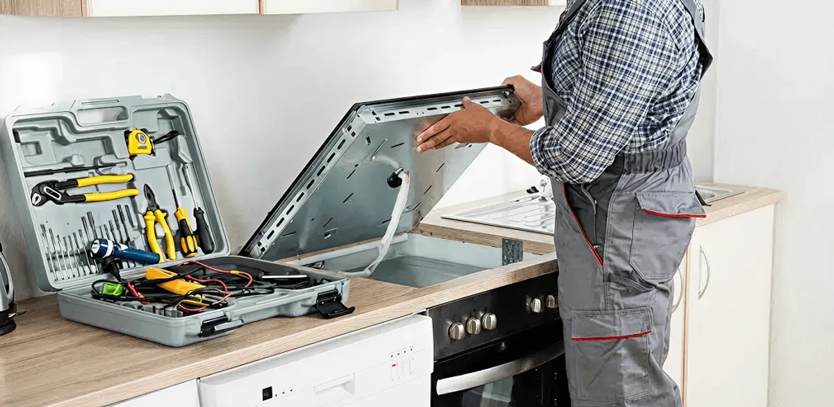 Handyman repairing a cooktop and checking wiring connections in Seattle, WA