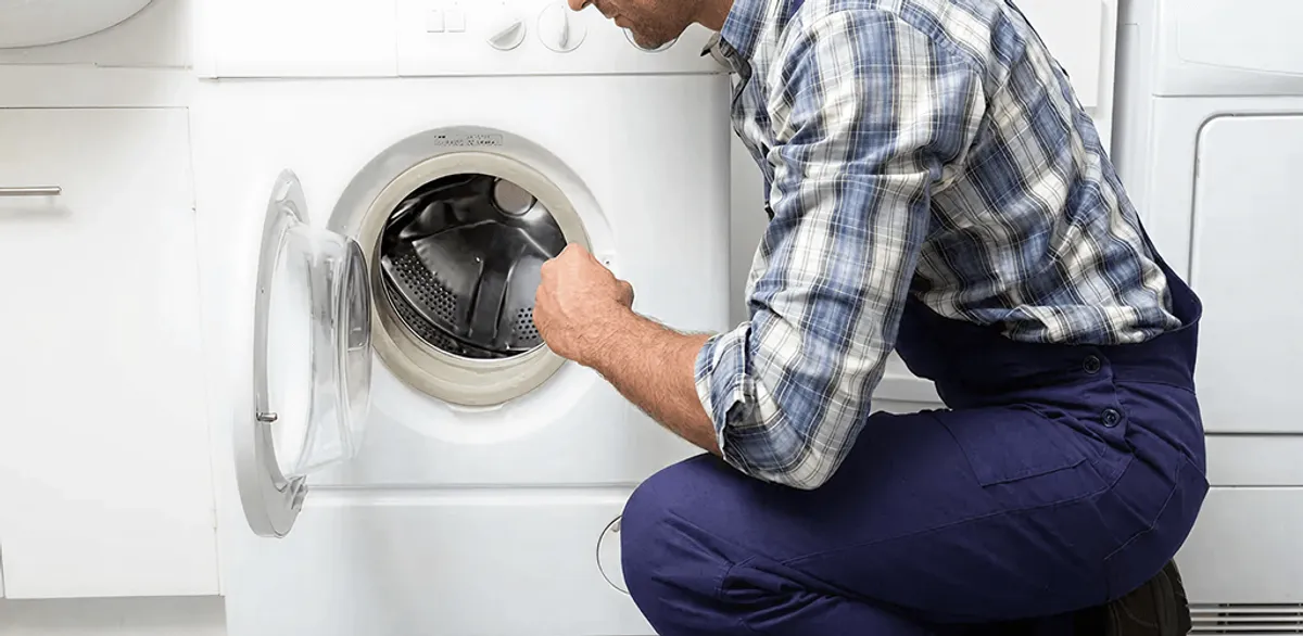 Handyman inspecting a dryer drum and internal parts for repair in Seattle, WA