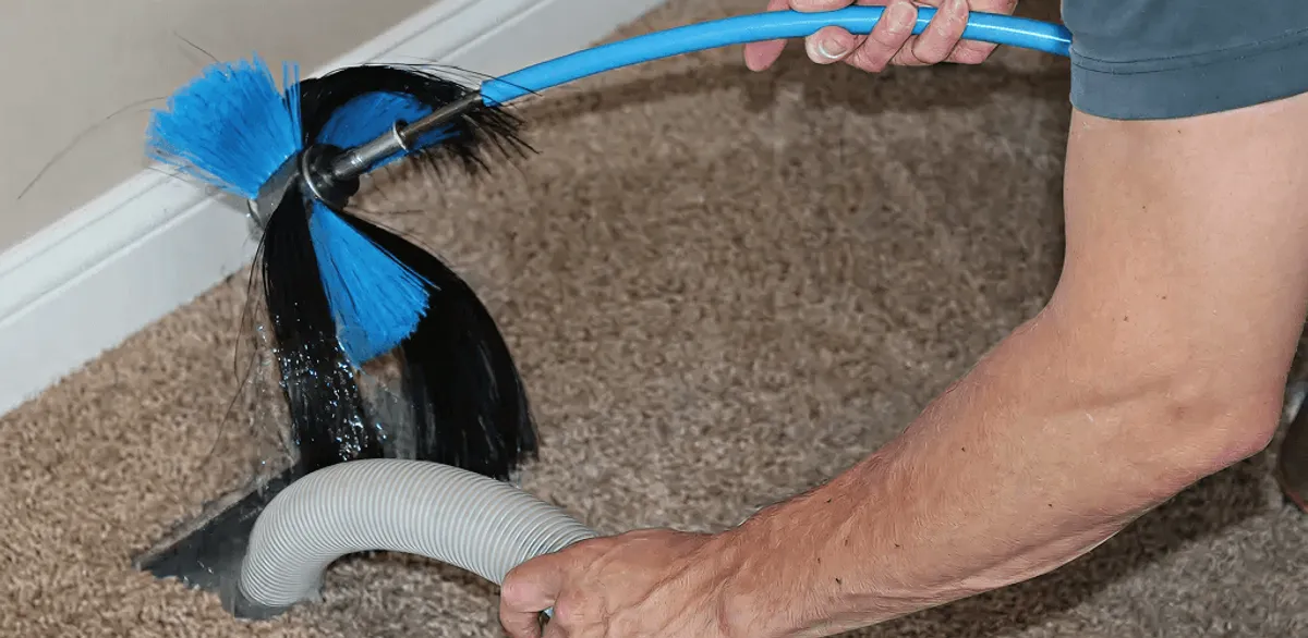 Dryer vent cleaning technician brushing lint from a vent line in Seattle, WA